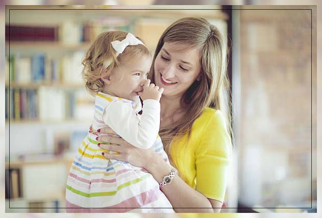 mom looking at her daughter putting fingers in her mouth