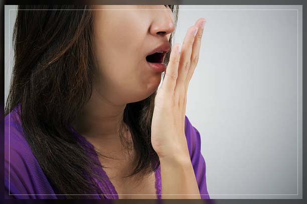 woman with bad breath smelling her breath
