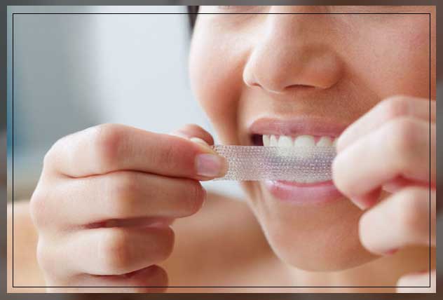 woman applying teeth whitening strips